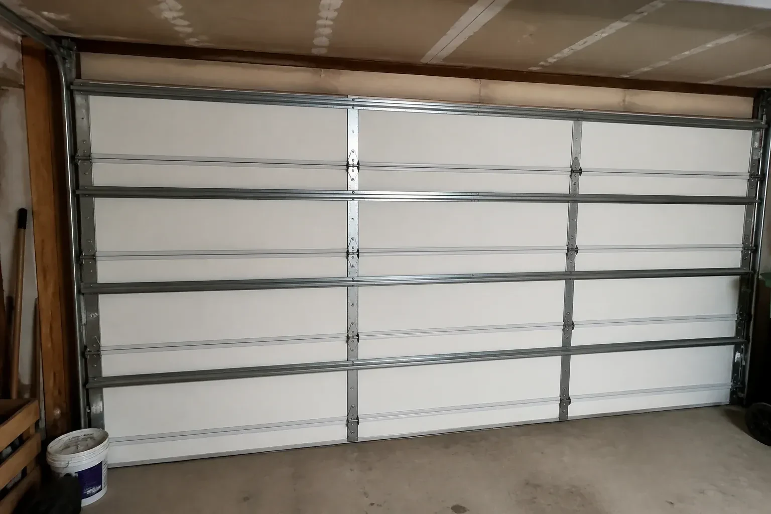 Interior of a closed sectional door with horizontal metal reinforcement struts. — Wind-Rated Garage Door Replacement, Oro-Medonte